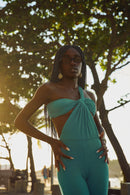 Full body shot of the Celestina jumpsuit in turquoise showing the elongated leg and architectural top.