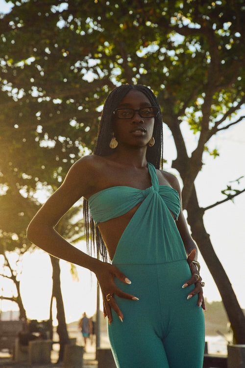 Full body shot of the Celestina jumpsuit in turquoise showing the elongated leg and architectural top.