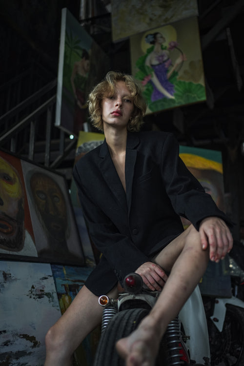 "Coincidencia?" Denim Blazer - Punta Loca Elevate your ensemble with the "Coincidencia?" Oversized Blazer,  Crafted from premium black denim, this blazer showcases pronounced shoulders, peak lapels, and functional flap pockets. Each blazer becomes a canvas, adorned with hand-painted figures that echo the vibrancy of street art. 