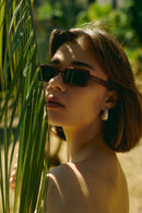 Woman wearing Singularidad burgundy Italian sunglasses outdoors — Punta Loca eyewear